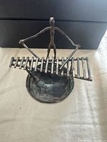 Front view of sterling silver figurine on slatted platform and round base