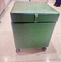 closed green vinyl ottoman on casters