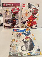 Front covers of all three LEGO activity books showing sealed minifigures