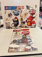Front view of three sealed LEGO activity books showing titles and minifigure blisters
