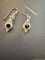 Both earrings front view showing onyx cabochons and silver detailing