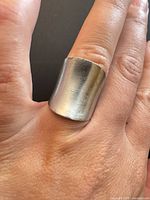 Ring on finger showing wide curved band profile