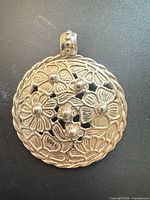 Front view of domed floral openwork pendant