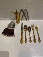 Group shot of all items: steak knives, pepper mill, crackers, gold-tone flatware