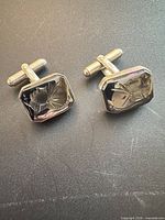 Both cufflinks showing carved hematite warrior panels and silver toggles