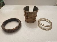 Wide brass cuff, stretch disc bangle, stack of thin bangles overview