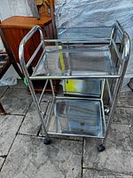 Full view of chrome three-tier cart on casters