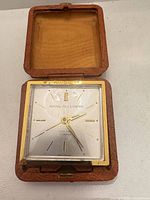 Clock in open case showing dial and bezel