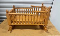 Overall view of wooden cradle with spindled sides
