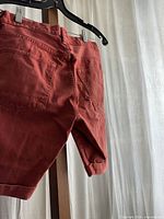 Back view of red rust cotton twill shorts showing rear pockets and hem