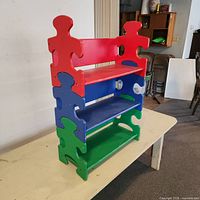 Front angled view of full bookshelf showing red, blue, green tiers
