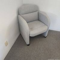 Front view of light gray fabric chair with visible seat stain