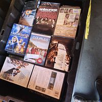 Top view of bin showing mixed DVD and Blu-ray cases including Fantastic Four, Entourage, Couples Retreat etc.