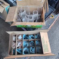 Opened box showing tall clear tumblers and second box with partitioned colored glassware