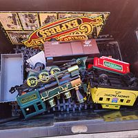 Assorted train components and track in bin including locomotive, caboose, tender, track sections and box panel