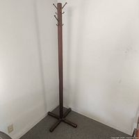 Full view of wooden coat rack showing cross base and height