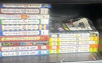 Two vertical stacks of Wimpy Kid books, mixed languages, titles and spine wear visible