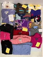 Overview of all folded sweaters showing variety and tags