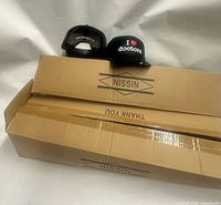 Two hats displayed on top of two cardboard boxes, front and back views visible
