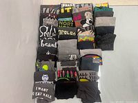Stacked rows of folded grey t-shirts showing variety of graphics