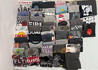 All 52 folded grey graphic T-shirts displayed on flat surface