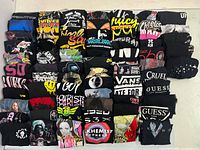 Front view showing multiple stacked black graphic T-shirts
