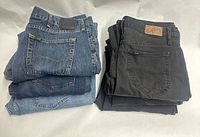 Two stacks of blue and black Lee jeans