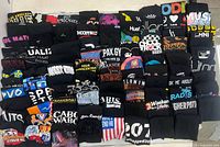 Front view showing stacks of folded black printed T-shirts