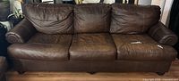 Front view of three-seat brown leather sofa