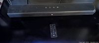 Front view of JBL sound bar with remote placed below