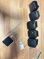 Five Blink Outdoor cameras stacked with sync module and cable visible
