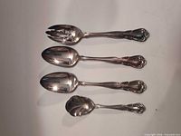 Four of the silver-plate spoons showing styles and ornate handles