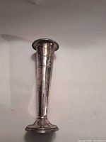 Full view of metal bud vase showing shape and tarnish