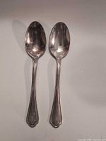 Front view of both spoons showing overall design and condition