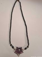 Full view of necklace laid flat showing overall design and clasp