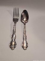 Fork and spoon laid flat showing full ornate handles and overall condition