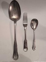 Front view of serving spoon, fork and small spoon