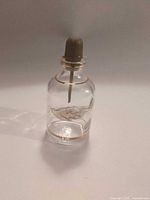 front angled view showing bottle, gold band, cap and bulb