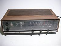 Front view showing flip clock display, AM/FM scale, controls and GE branding