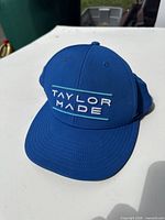 Front view of blue TaylorMade cap showing embroidered logo