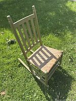 Full view of green child rocking chair on grass