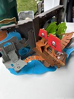 Playset opened showing ship, sails, water and rocky features