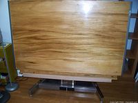 Front view of drafting table showing full wood surface and metal base