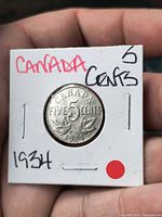 Reverse of 1934 Canadian 5-cent coin in holder