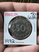 Obverse of 1972 Malta 50 cent coin in flip showing denomination wreath