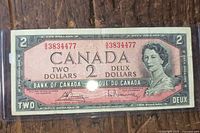 Obverse of 1954 Canada $2 banknote in sleeve showing serial number and portrait