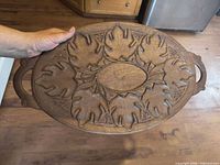Top view of oval carved wood tray showing leaf motif and handles