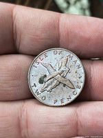 Reverse side showing ISLE OF MAN TWO PENCE with birds over island silhouette, corrosion visible