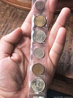 Front view of six coins in plastic strip