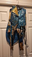 Full view of jacket over jumpsuit on hanger